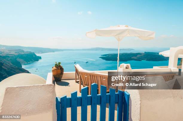 bench on terrace overlooking caldera of santorini greece - griechische inseln stock-fotos und bilder