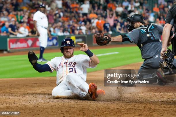 Houston Astros left fielder Derek Fisher slides at home-plate scoring on a sacrifice hit in the eighth inning of a MLB game between the Houston...