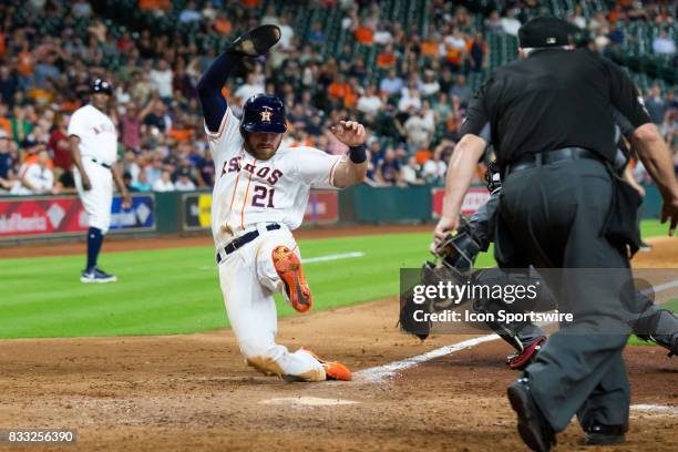 Houston Astros left fielder Derek Fisher slides at home-plate scoring on a sacrifice hit in the eighth inning of a MLB game between the Houston...