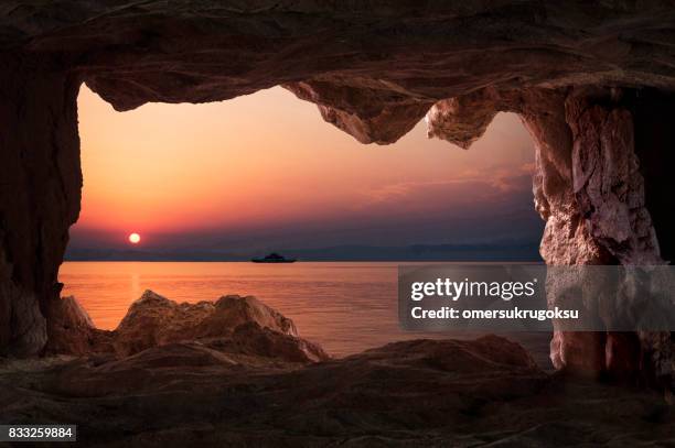 blick auf den sonnenuntergang von der höhle im inneren in thásos, griechenland - the cove stock-fotos und bilder