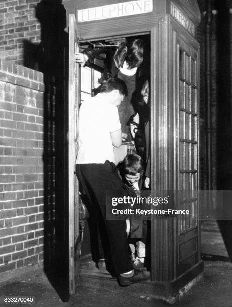 Jeunes blousons noirs dans une cabine téléphonique, Royaume-Uni, circa 1950.