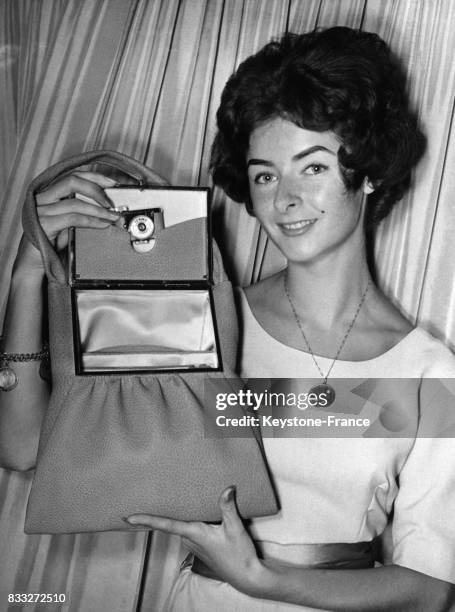 Jeune femme présentant un sac en cuir équipé d'un appareil photo cousu dans une pochette spéciale, à l'occasion de la foire du cuir, à Offenbach,...