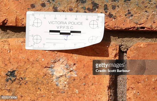 Victoria Police note is stuck next to a bullet hole is a brick next to the front door after a drive-by shooting at a property in Narre Warren in...