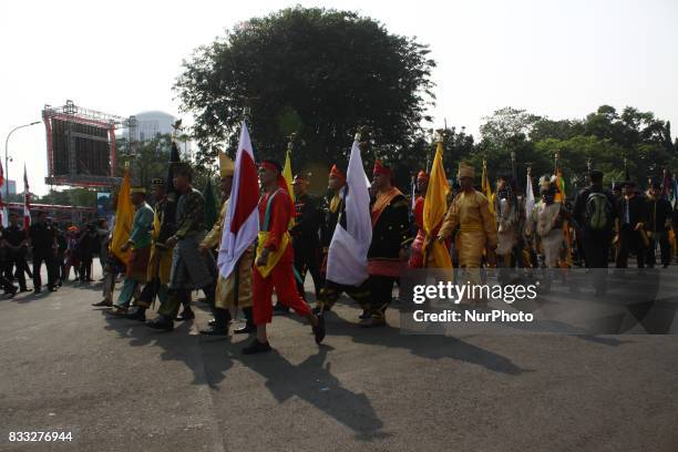 The marching band team from Indonesian military and police along with people with traditional dresses escorted the horse cart carriying the Bendera...