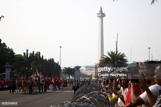 The marching band team from Indonesian military and police along with people with traditional dresses escorted the horse cart carriying the Bendera...