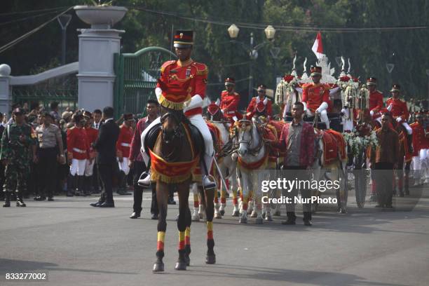 The marching band team from Indonesian military and police along with people with traditional dresses escorted the horse cart carriying the Bendera...