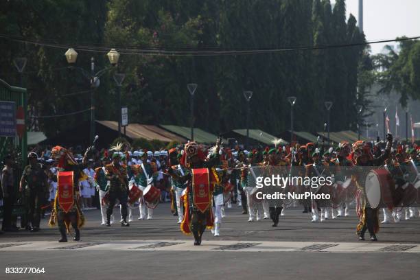 The marching band team from Indonesian military and police along with people with traditional dresses escorted the horse cart carriying the Bendera...
