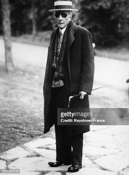 Portrait de John Davison Rockefeller qui a accepter de poser pour les photographes avant d'entrer dans une église, à condition que les photographes y...