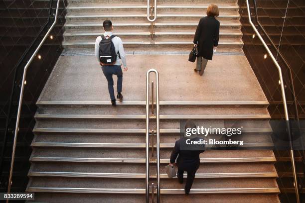 Morning commuters walk up a flight of stairs at Martin Place in Sydney, Australia, on Thursday, Aug. 17, 2017. Australian employers added more jobs...