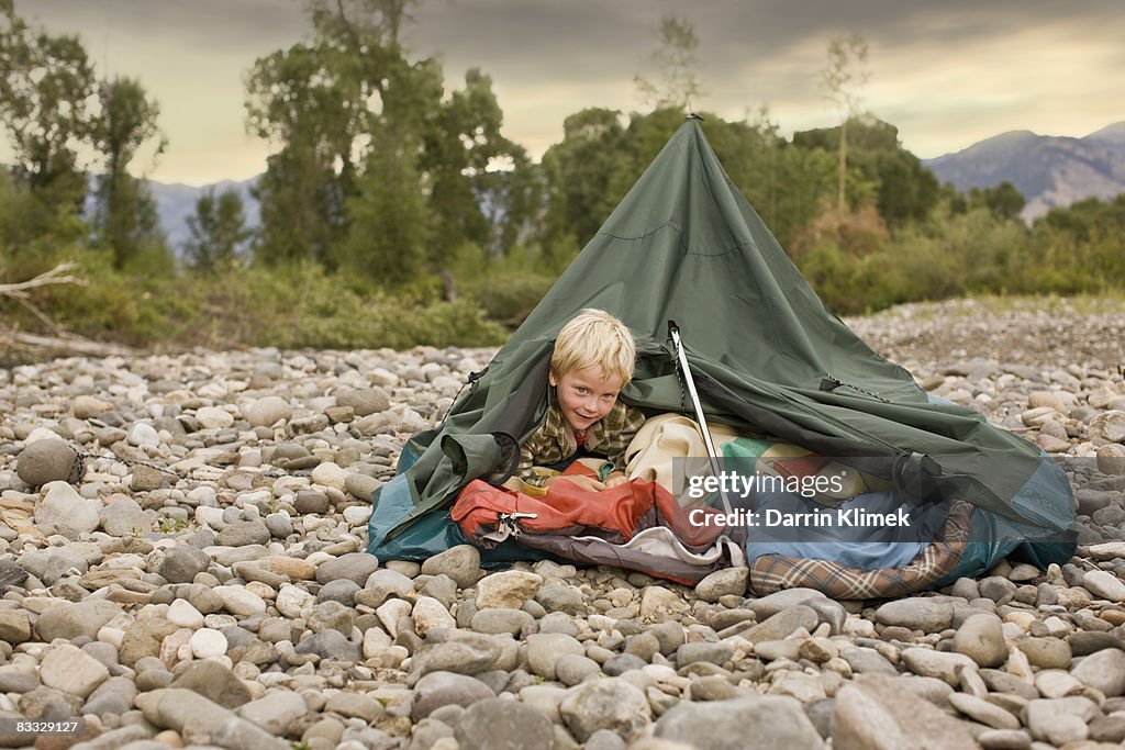 Young boy playing in collapsed tent