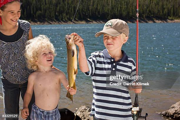 boy holding fish he caught - preteen girl no shirt stock pictures, royalty-free photos & images