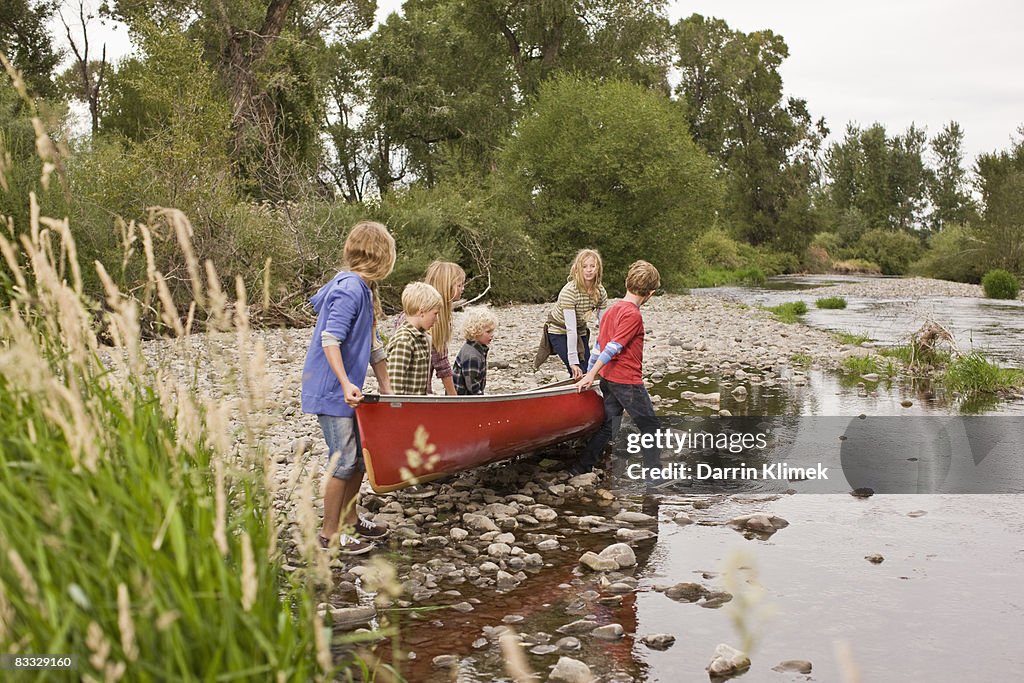 Siblings canoeing on river