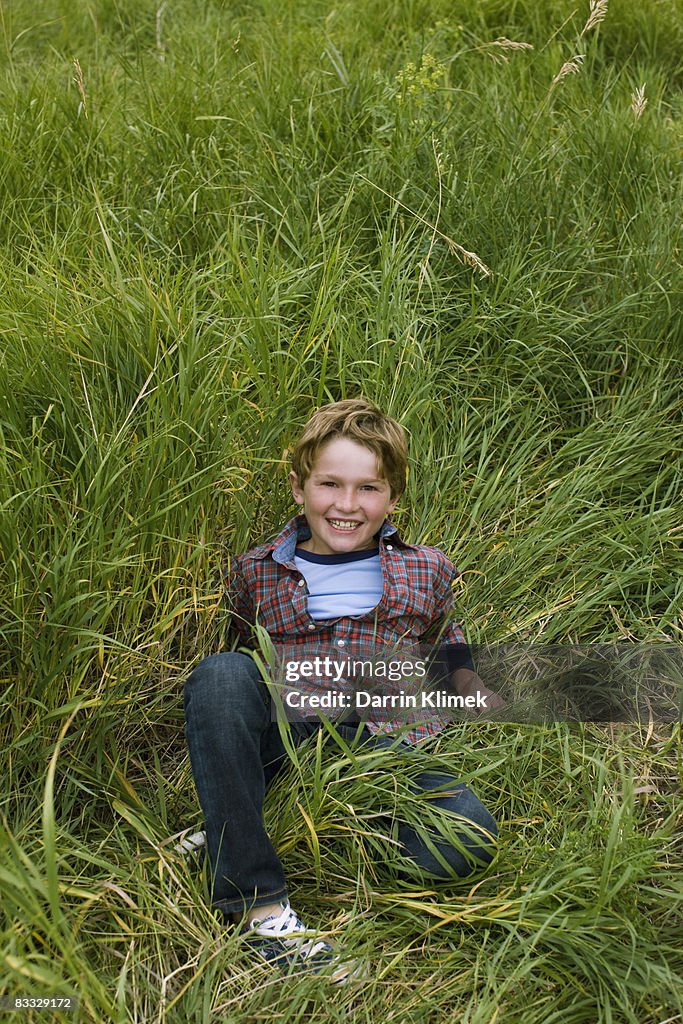 Smiling boy sitting in grass