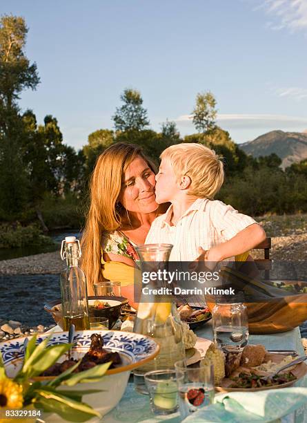 son kissing mother after dinner - gratitude jar stock pictures, royalty-free photos & images