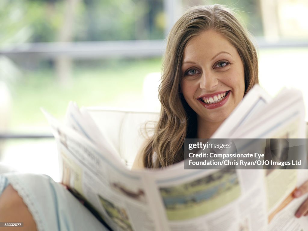 Young woman reads newspaper