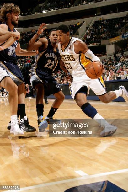 Danny Granger of the Indiana Pacers drives past Rudy Gay and Marc Gasol of the Memphis Grizzlies at Conseco Fieldhouse on October 17, 2008 in...