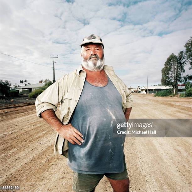 large man standing on dirt road - australian portrait stock-fotos und bilder