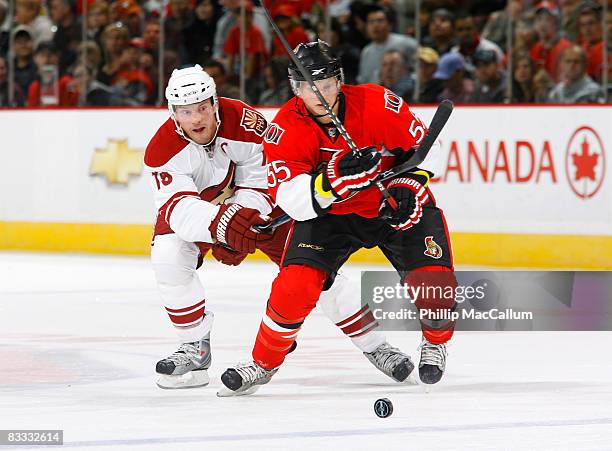 Shane Doan of the Phoenix Coyotes tries to hook up Brian Lee of the Ottawa Senators as he carries the puck up ice during the second period of a game...