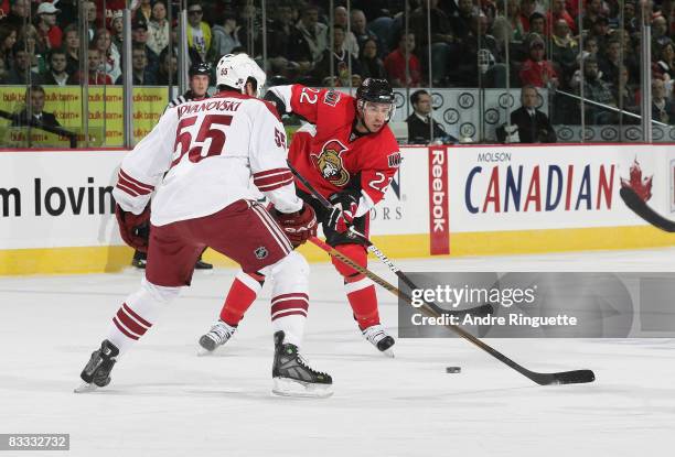 Chris Kelly of the Ottawa Senators shoots the puck against Ed Jovanovski of the Phoenix Coyotes at Scotiabank Place on October 17, 2008 in Ottawa,...