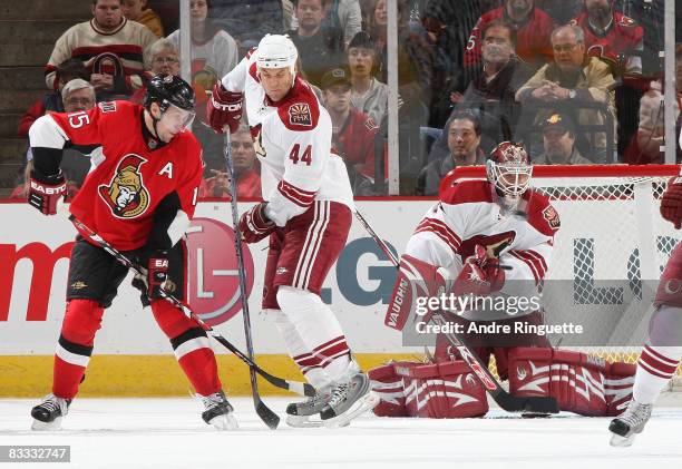 Ilya Bryzgalov of the Phoenix Coyotes makes a save as Dany Heatley of the Ottawa Senators tries for a defection with Kurt Sauer of the Phoenix...