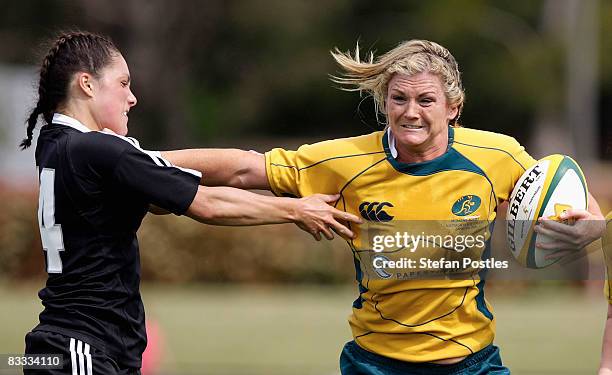 Debby Hodgkinson of the Wallaroos fends off a tackle by Victoria Blackledge of the Black Ferns during the second test match between the Australian...