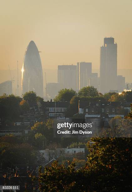 The skyscrapers of the City loom over the homes of North London at sunrise, on October 17, 2008 in London, England.