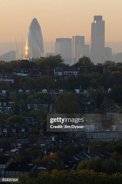 The skyscrapers of the City loom over the homes of North London at sunrise, on October 17, 2008 in London, England.