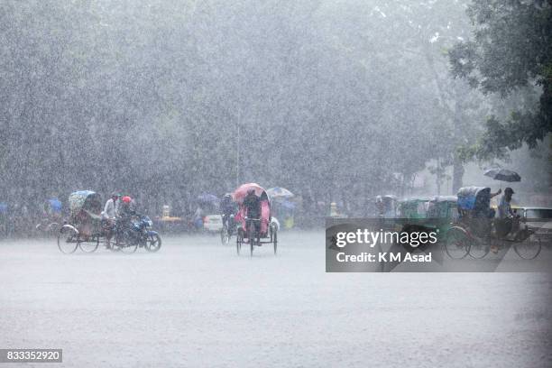 Rickshaw puller carrying passenger when heavy rainfall maid in the Dhaka city.