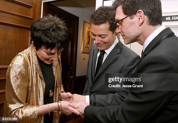 Liza Minnelli looks at Michael Feinstein and Terrence Flannery's wedding rings during their wedding ceremony held at a private residence on October...