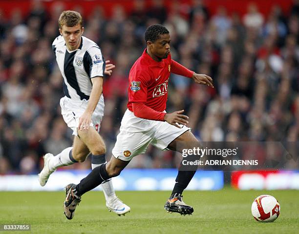 Manchester United's French defender Patrice Evra runs with the ball chased by West Bromwich Albion's James Morrison during the Premiership football...