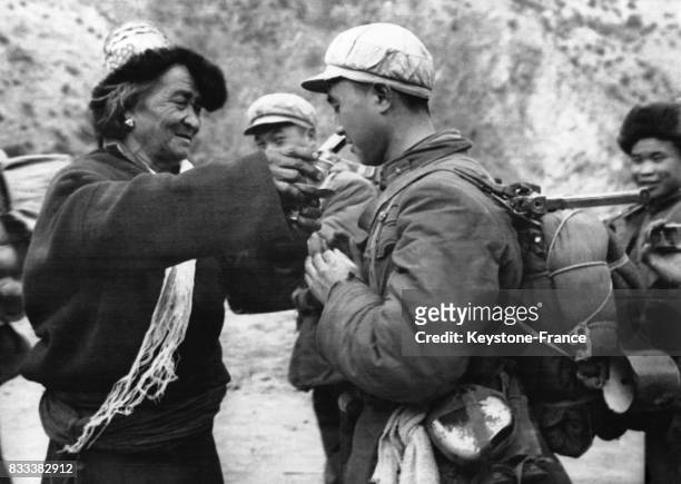 Un vieil homme tibétain fait ses adieux à un garde de la frontière chinoise en lui offrant un verre de vin, en Chine en décembre 1962.