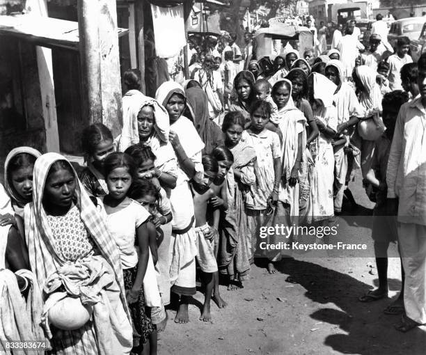 Immense file d'attente devant un magasin d'alimentation qui vend du riz à un tarif imposé par le gouvernement, à Calcutta, Inde en octobre 1963.