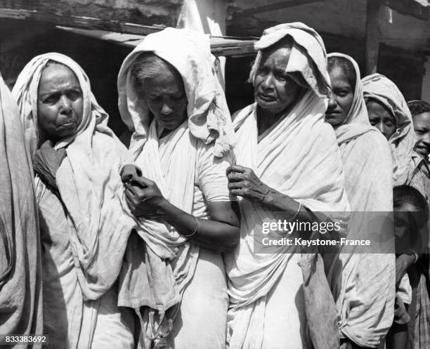 De vieilles femmes font la queue devant un magasin s'alimentation sous la chaleur pendant de longues heures, à Calcutta, Inde en octobre 1963.