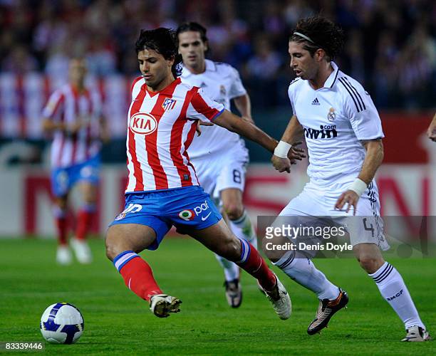 Kun Aguero of Atletico Madrid swerves past Sergio Ramos of Real Madrid goes for a high ball against Paulo Assuncao of Atletico Madrid during the La...