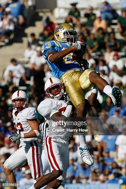 Nelson Rosario of the UCLA Bruins catches a pass over Kris Evans and Bo McNally of the Stanford Cardinal during the second half on October 18, 2008...