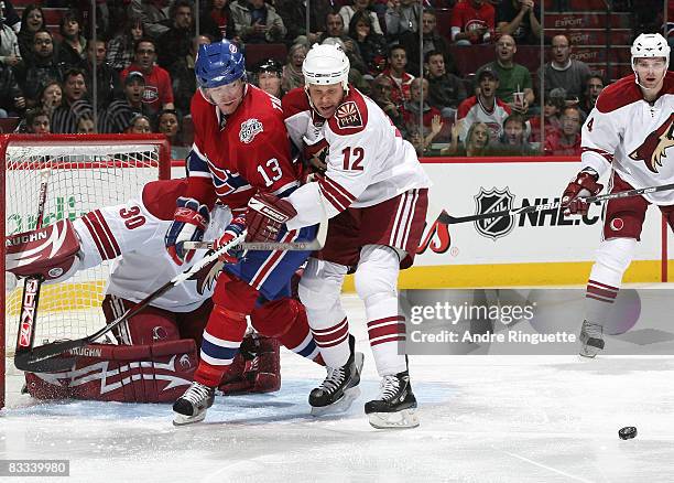 Olli Jokinen of the Phoenix Coyotes defends against Alex Tanguay of the Montreal Canadiens in the crease at the Bell Centre on October 18, 2008 in...