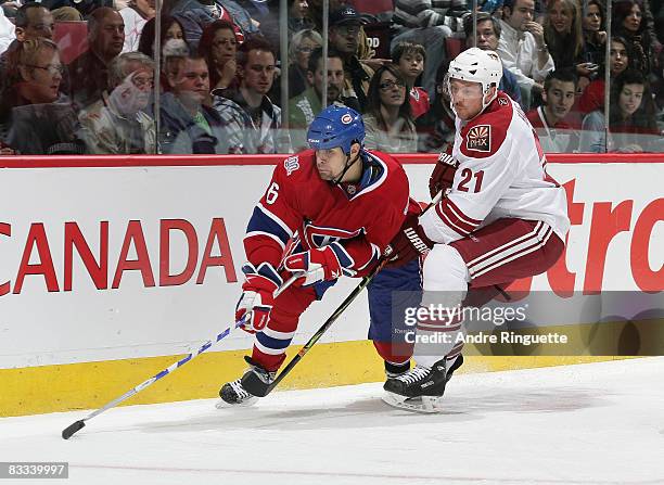 Tom Kostopoulos of the Montreal Canadiens controls the puck against David Hale of the Phoenix Coyotes in first period action at the Bell Centre on...