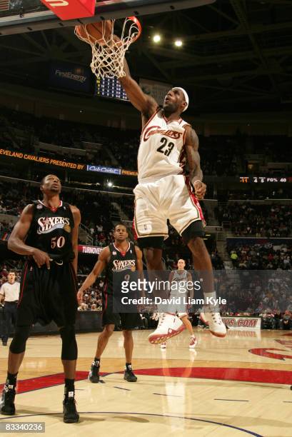 LeBron James of the Cleveland Cavaliers dunks the ball in front of Theo Ratliff and Andre Iguodala of the Philadelphia 76ers at The Quicken Loans...
