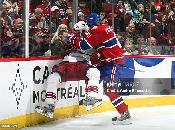 Mike Komisarek of the Montreal Canadiens bodychecks Martin Hanzal of the Phoenix Coyotes off his feet at the Bell Centre on October 18, 2008 in...