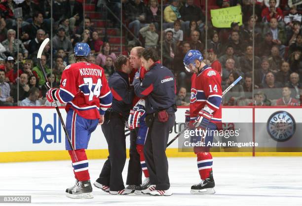 Andrei Kostitsyn of the Montreal Canadiens is helped off the ice by team trainers after a hit in the second period of a game against the Phoenix...