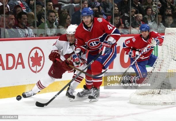 Maxim Lapierre of the Montreal Canadiens and Ed Jovanovski of the Phoenix Coyotes battle for puck possession behind the net at the Bell Centre on...