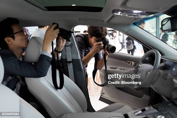 Members of the media take photographs of the interior of the Hyundai Motor Co. Next generation fuel-cell electric sport utility vehicle during an...