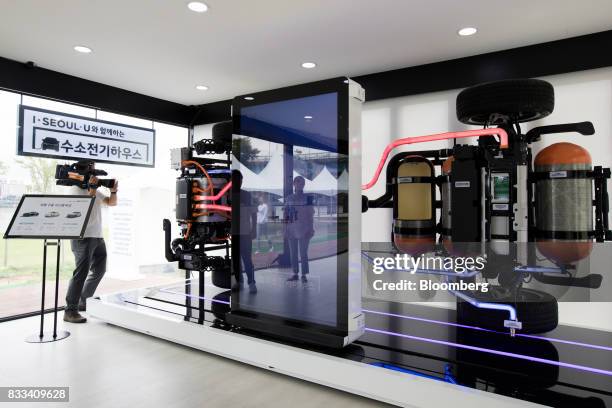 Member of the media films the Hyundai Motor Co. Next generation fuel-cell electric sport utility vehicle powertrain system during an unveiling event...