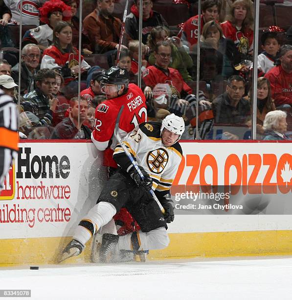 Mike Fisher of the Ottawa Senators is checked into the boards by Michael Ryder of the Boston Bruins at Scotiabank Place on October 18, 2008 in...