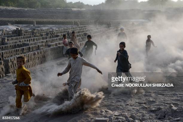 In this photograph taken on August 16 Afghan children run as they play along a dusty road on the outskirts of Jalalabad.