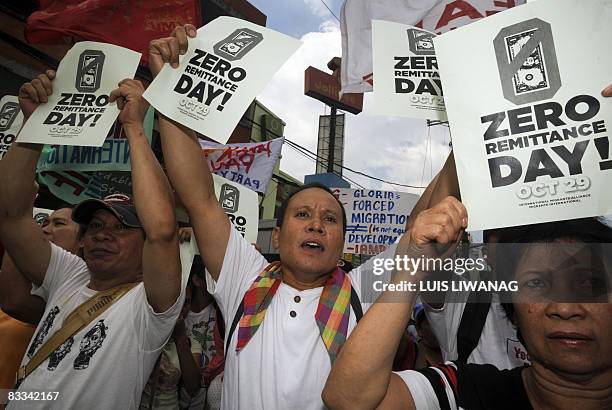 Filipino migrants and workers hold up placards saying "Zero Remittance Day" during a protest rally against forced migration and systematic...