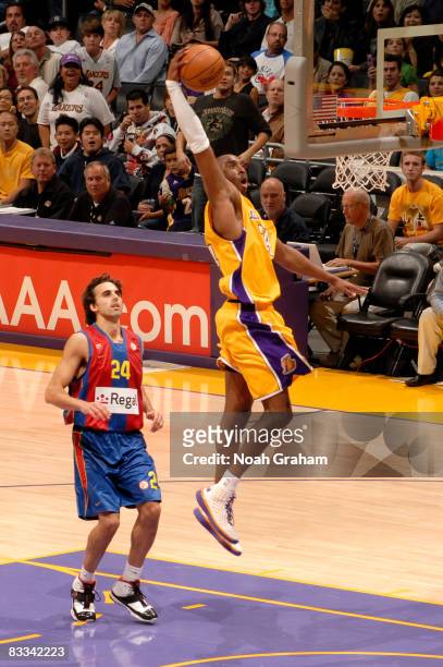 Kobe Bryant of the Los Angeles Lakers goes up for a dunk while Victor Sada of Regal FC Barcelona looks on during their game at Staples Center on...
