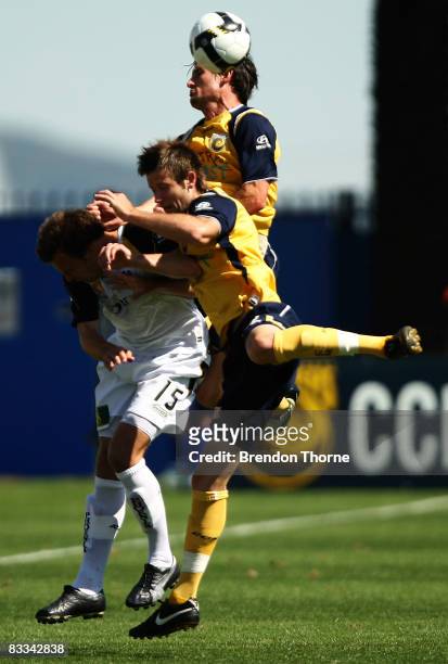 Adam Kwasnik of the Phoenix competes with Matthew Osman and Andrew Clark of the Mariners during the round eight A-League match between the Central...