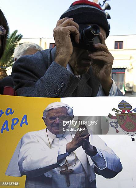 Man takes a picture as Pope Benedict XVI passes by in his Popemobile upon his arrivall in Pompei on October 19, 2008. The Pope will celebrate, later...