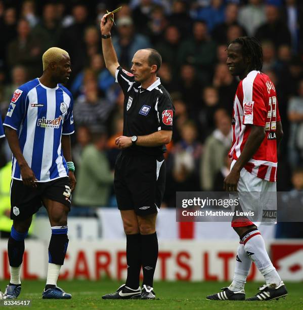 Referee Mike Dean gives a yellow card to Akpo Sodje of Sheffield Wednesday and Ugo Ehiogu of Sheffield United for fighting during the Coca-Cola...